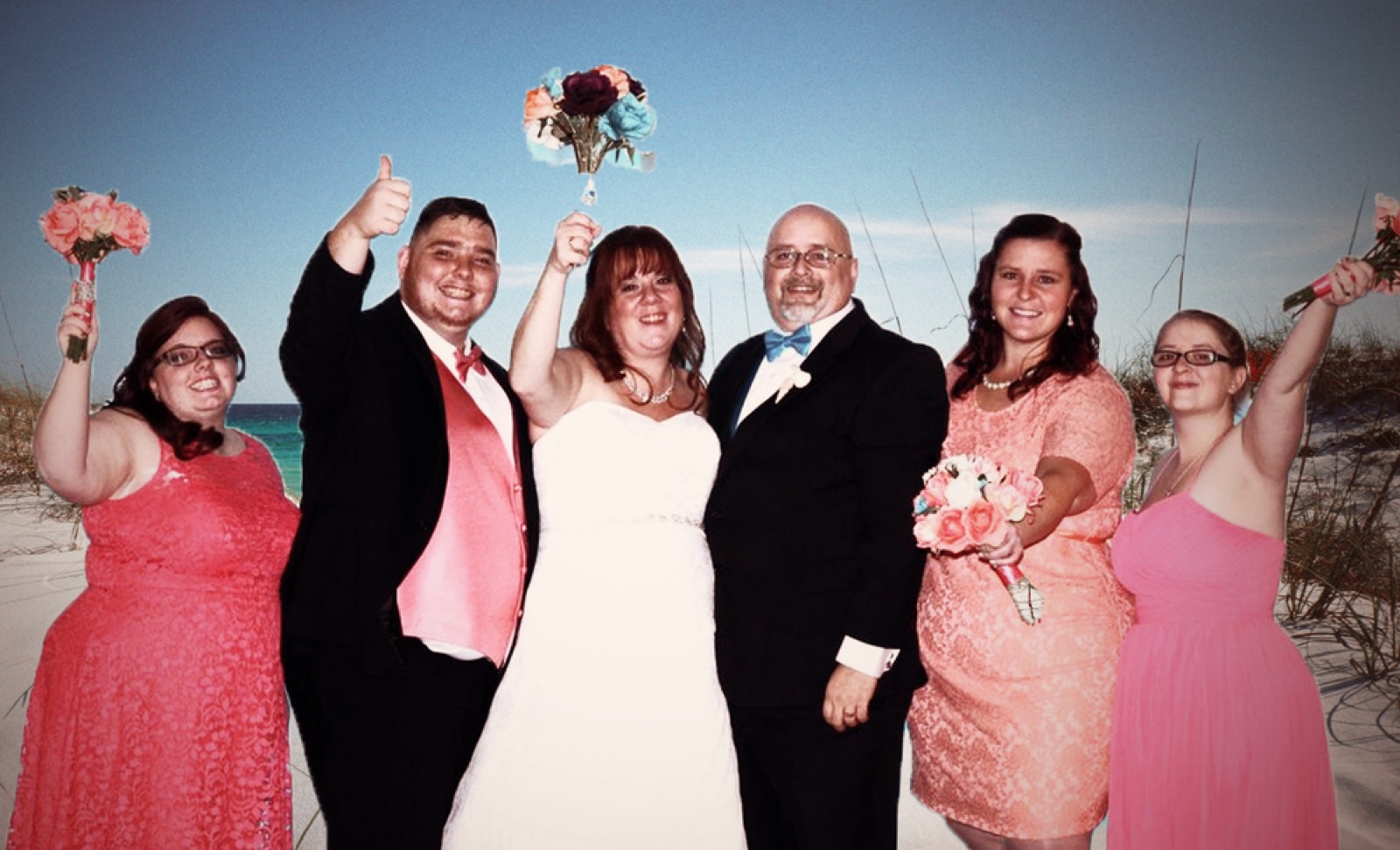 A wedding party celebrating on a beach